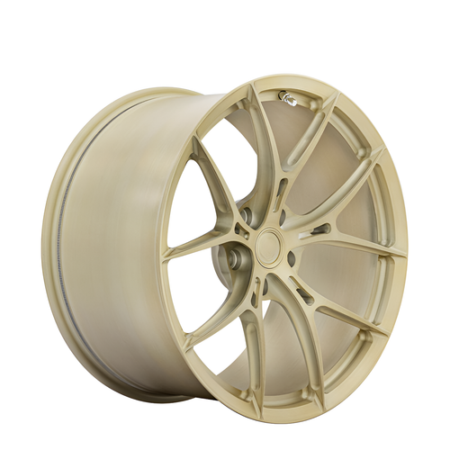 Gold twin spoke forged alloy wheel on white background