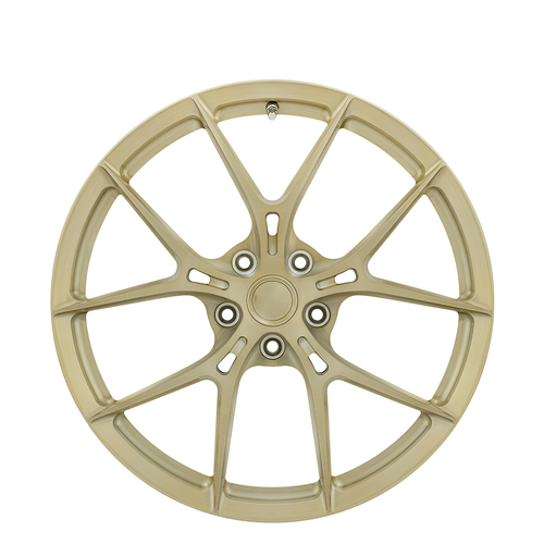 Gold twin spoke forged alloy wheel on white background