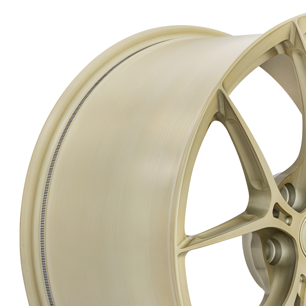 Gold twin spoke forged alloy wheel on white background